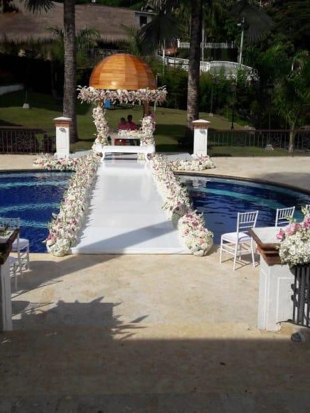 Pasillo floral montado sobre la piscina, con gazebo al fondo