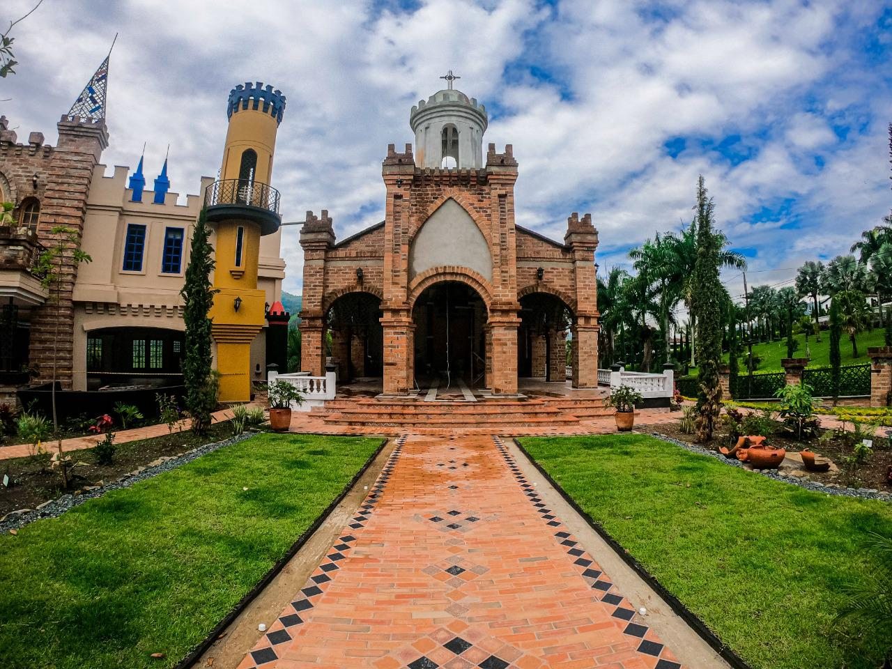 Capilla de piedra y torres de El Castillo, con el pasillo empedrado de acceso